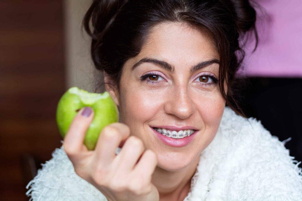 Patient eating comfortably with lingual braces fitted behind the teeth