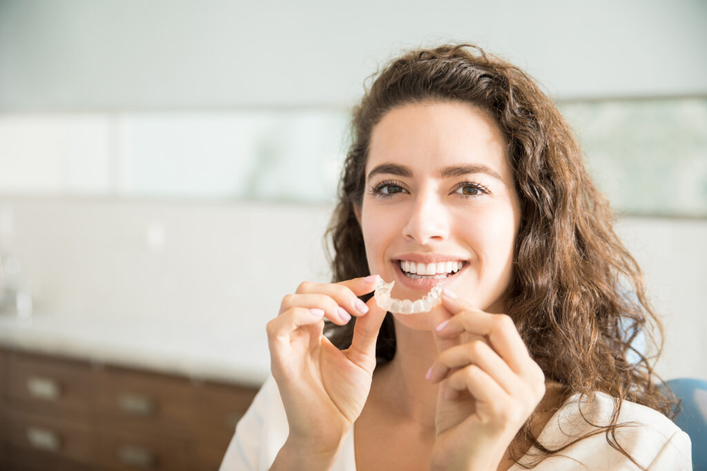 Patient holding clear aligners at Mint Dental Care